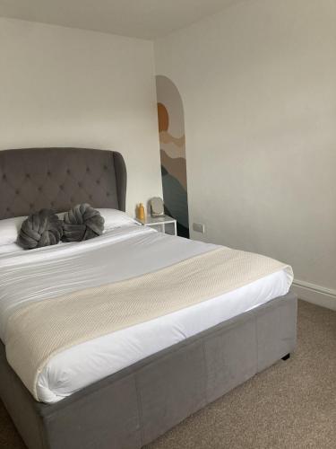 a bedroom with a large bed with white sheets at The Spacious Stay Stratford in London