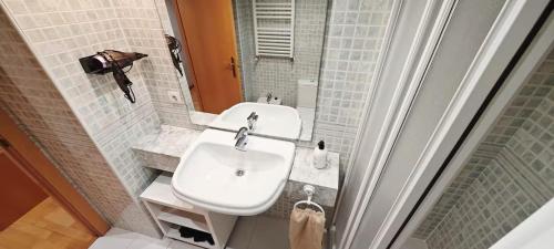 a bathroom with a white sink and a mirror at Great apartment with a pool on the beach in Barcelona in Badalona