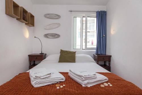 a bedroom with a bed with towels on it at Calheta House in Luz in Luz