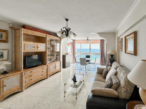 Una sala de estar con un sofá y un televisor. en Carabelas 3, en Benidorm