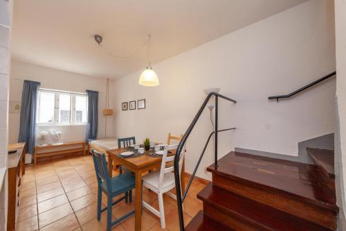 a living room with a dining room table and a staircase at B94 - Casa dos Peixeiros in Lagos in Lagos