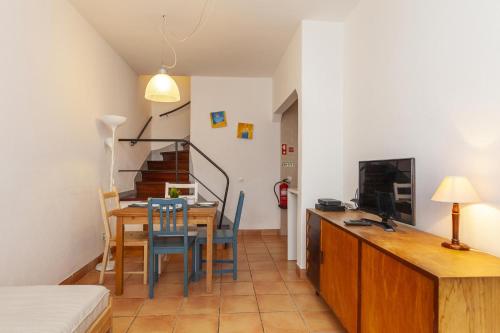 a living room with a dining room table and a television at B94 - Casa dos Peixeiros in Lagos in Lagos