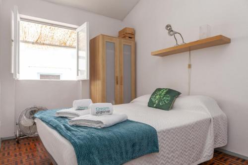 ラゴスにあるCasa dos Peixeiros in Lagosのベッド2台、タオル、窓が備わる客室です。