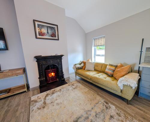 un salon avec un canapé et une cheminée dans l'établissement Creggan Deveskey Cottage, à Carrickmore