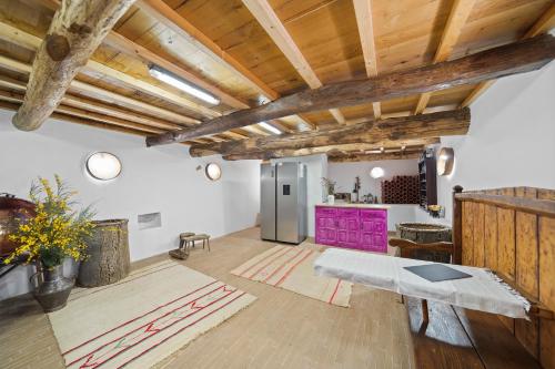 a living room with wooden ceilings and a purple table at Casa da Edrosa in Edrosa
