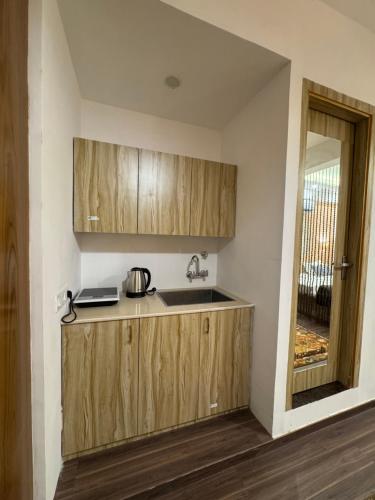 a kitchen with wooden cabinets and a sink at Casa Musafir in Zirakpur