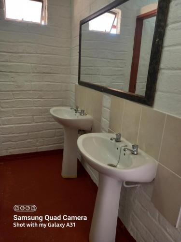 a bathroom with two sinks and a mirror at Mesklip Caravan Park in Springbok