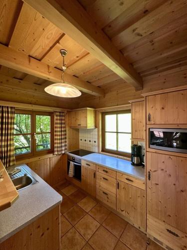 a large kitchen with wooden cabinets and a ceiling at Chalet Amade in Forstau