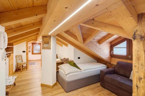 a room with a bed and a couch in a attic at Chalet Lamada in Livigno