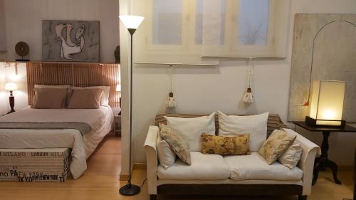 1 dormitorio con 1 cama y 1 sofá con almohadas en Habitacion en apartamento Vegueta, en Las Palmas de Gran Canaria