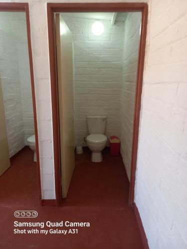 a small bathroom with a toilet in a hallway at Mesklip Caravan Park in Springbok