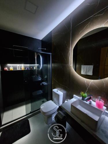 a bathroom with a toilet and a sink and a mirror at Residencia SG - Casa Duplex in Encarnación