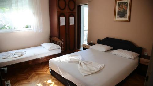 two beds in a room with a window at Apartaments A4 in Ulcinj