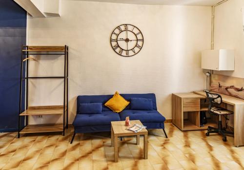 アルルにあるappartement cosy Arles centre, proche des Arènesのリビングルーム(青いソファ、壁掛け時計付)