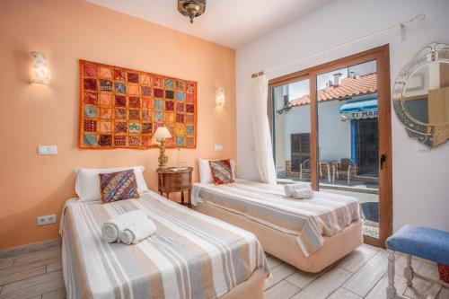 two beds in a room with a window at Alvor Ar de Mar Apart in Alvor