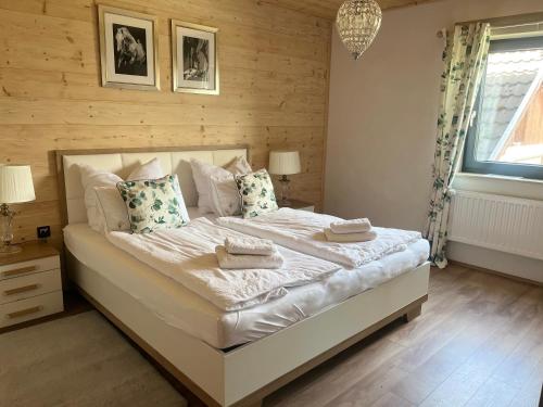 a bedroom with a large white bed with pillows at Luxury Chalet Suite suitable for 4 Guests, Living Room, Kitchen and Games Room in Tamsweg