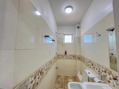 a bathroom with four toilets and sinks and a window at Blue Reef Holiday Home in Mombasa