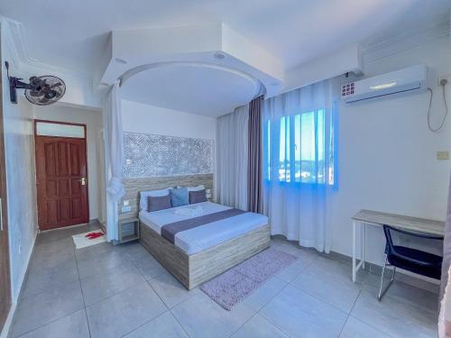 a bedroom with a bed and a desk in it at Blue Reef Holiday Home in Mombasa