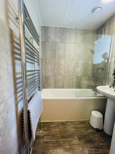 a bathroom with a tub and a sink at Smugglers Neuk- cosy flat for 2 in Cellardyke