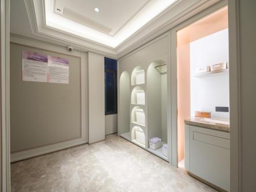 a hallway with a door and a refrigerator at Mercure Xi'an Stadium Hotel in Xi'an