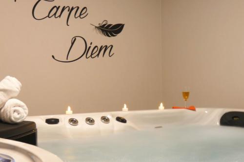 a bathroom with a tub with candles and a sign that says caredn at L'HACIENDA DUO a romantic getaway with a private spa in Charavines
