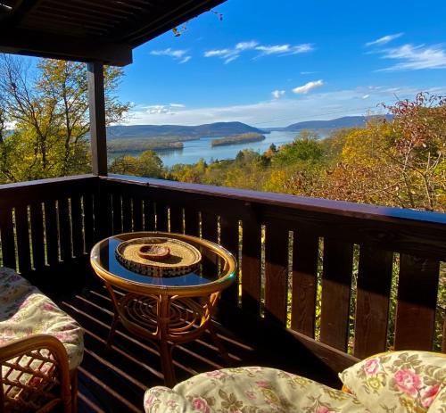 a balcony with a table and chairs and a view of a lake at Szegfű33 Vendégház in Zebegény