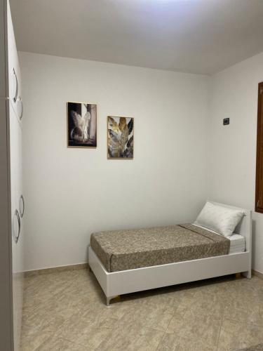 a bed in a room with two pictures on the wall at Villa Sota Divjakë in Divjakë