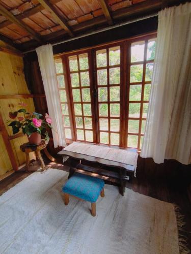 a room with a bench in front of a window at Chalé Candeia no Matutu in Aiuruoca
