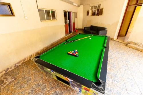 een pooltafel in een woonkamer met een flatscreen-tv bij Jade Inn in Arusha