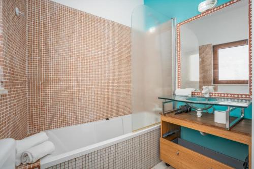 a bathroom with a tub and a sink at Alvor Ar de Mar Apart in Alvor