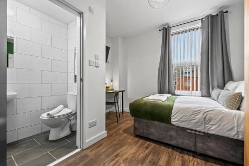 1 dormitorio con cama, aseo y ventana en NEW! 4BR 4BATH, Perfect for Contractors, Smart TVs, WiFi, en Coventry