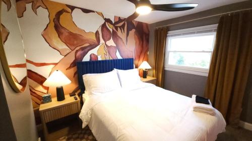 The Funky Fun Haus - Pickleball, Hot Tub, Arcade في كولومبوس: غرفة نوم بها سرير ولوحة على الحائط