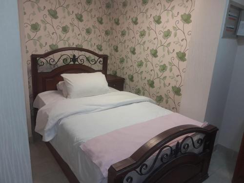 a bedroom with a bed with white sheets and floral wallpaper at Luxury Sea View Apartment in Four Seasons Alexandria in Alexandria