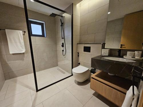ein Badezimmer mit Dusche, Toilette und Waschbecken in der Unterkunft Al Faris Suites 2 in Juffair