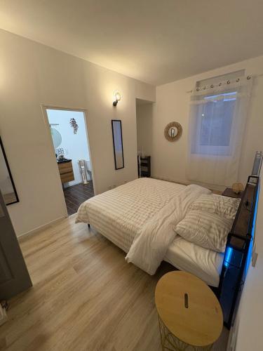 une chambre avec un grand lit et une table en bois dans l'établissement Comme à la maison, à Carcassonne