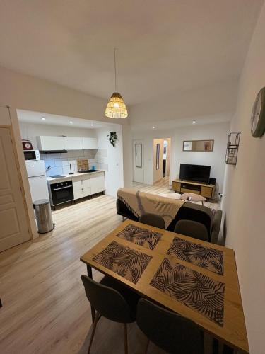 un salon avec une table et une cuisine dans l'établissement Comme à la maison, à Carcassonne