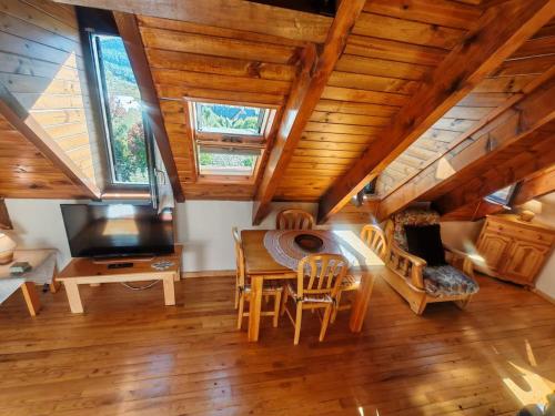 a dining room with a table and chairs and a television at Dúplex con chimenea en la Vall de Boí - Falcó 6 in Pla de l'Ermita