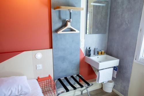 a small bathroom with a sink and a bed at ibis budget Haguenau Strasbourg Nord in Haguenau