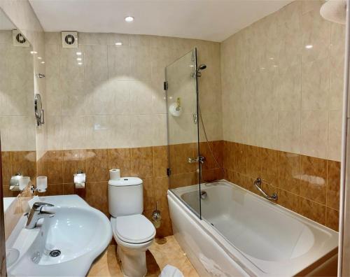 a bathroom with a toilet and a tub and a sink at Duni Holiday Village - All Inclusive in Sozopol