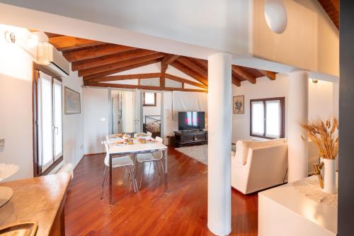 ein Esszimmer und ein Wohnzimmer mit Tisch und Stühlen in der Unterkunft Centralissimo vista Municipio, Elegante con Rooftop in Pordenone