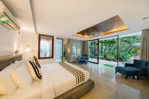 een slaapkamer met een groot bed en een groot raam bij THE MUSE Pantai Nyanyi Villa in Canggu