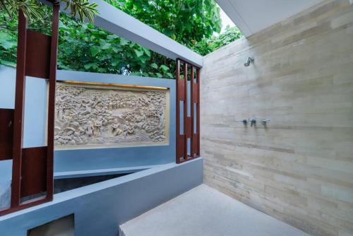 een badkamer met een stenen muur en een raam bij THE MUSE Pantai Nyanyi Villa in Canggu