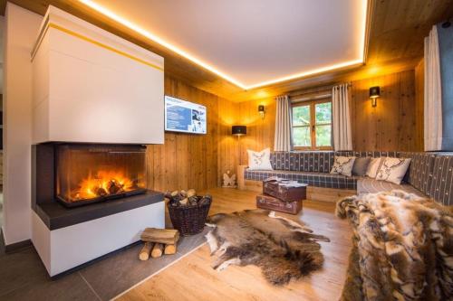 ein Wohnzimmer mit Kamin und Couch in der Unterkunft Bachgut Jagdhaus Chalet in Saalbach-Hinterglemm