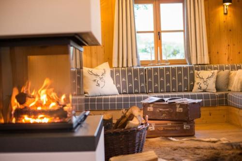 ein Wohnzimmer mit Couch und Kamin in der Unterkunft Bachgut Jagdhaus Chalet in Saalbach-Hinterglemm