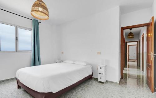 a bedroom with a white bed and a large window at wonderful tila house, facing the sea in La Garita