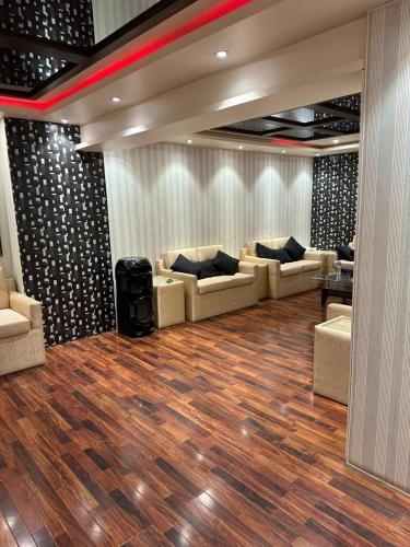 een woonkamer met banken en een houten vloer bij MeetUp Karachi in Karachi