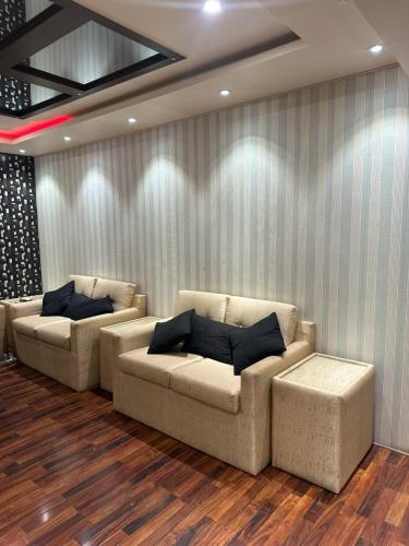 een woonkamer met twee banken voor een muur bij MeetUp Karachi in Karachi