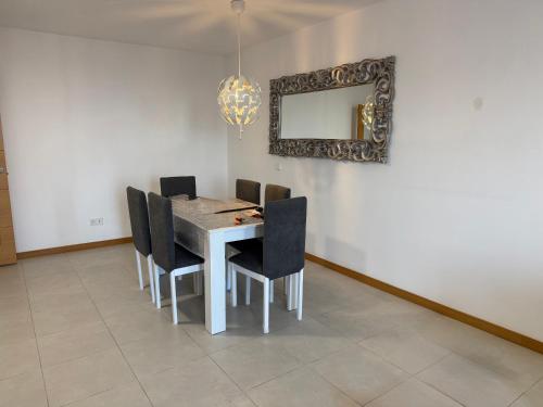 Un comedor con una mesa y sillas y un espejo. en NG SANTA CRUZ - Santa Cruz de Tenerife, en Santa Cruz de Tenerife