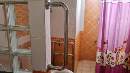a bathroom with a shower curtain and a toilet at Supunpong Pool Villa in Nakhon Nayok