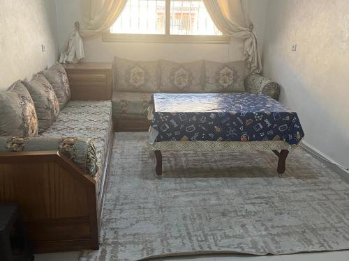 a living room with a couch and a bed at avenue hassan 2 agadir in Oulad Akkou